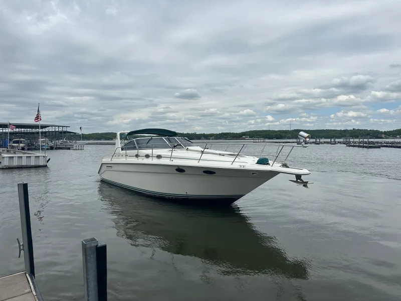 Slide: The Image of 1994 Sea Ray 370 Express Cruiser docked on a calm lake under cloudy skies. - 13