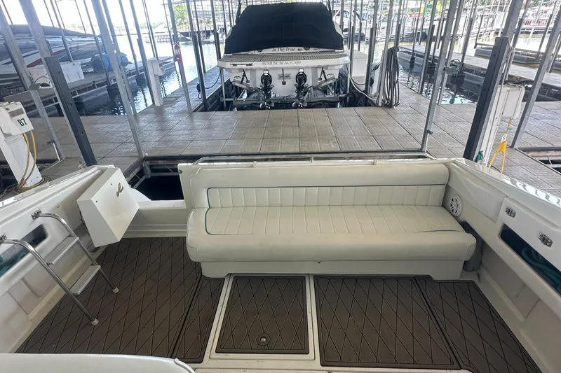 Slide: The Image of 1994 Sea Ray 370 Express Cruiser interior with white seating and docked marina view. - 17