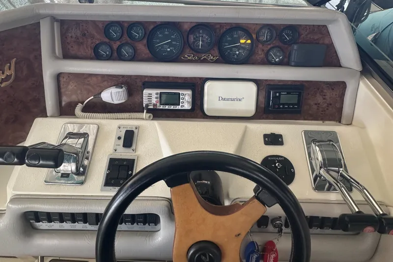 Slide: The Image of 1994 Sea Ray 370 Express Cruiser dashboard with steering wheel and control panel. - 21