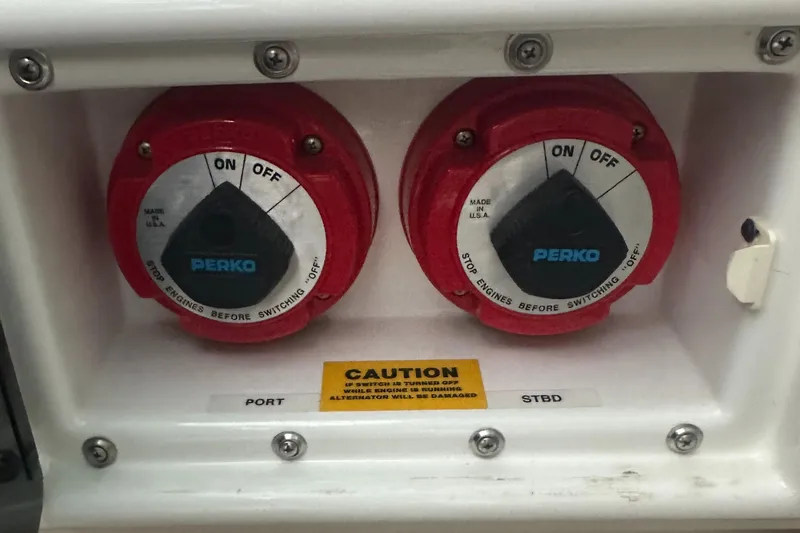 Slide: The Image of Battery switches on a 1994 Sea Ray 370 Express Cruiser, labeled "Perko" with caution sign. - 24