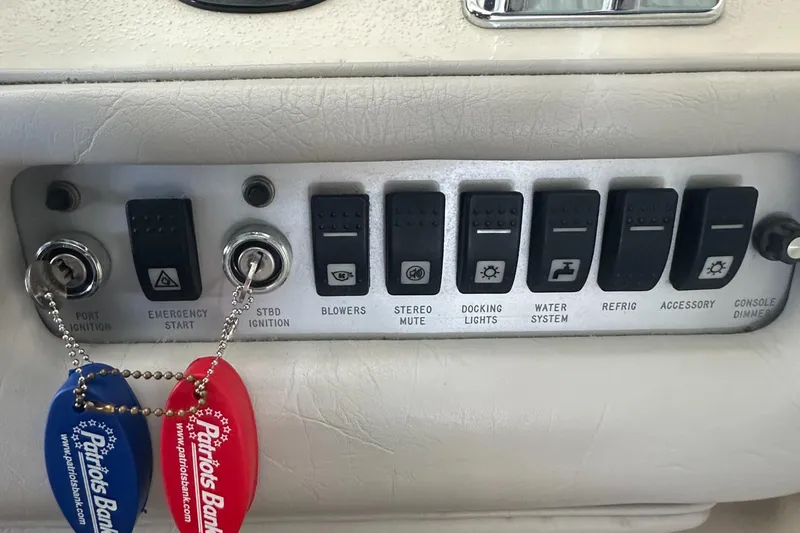Slide: The Image of Control panel of a 1994 Sea Ray 370 Express Cruiser with labeled switches and ignition keys. - 25