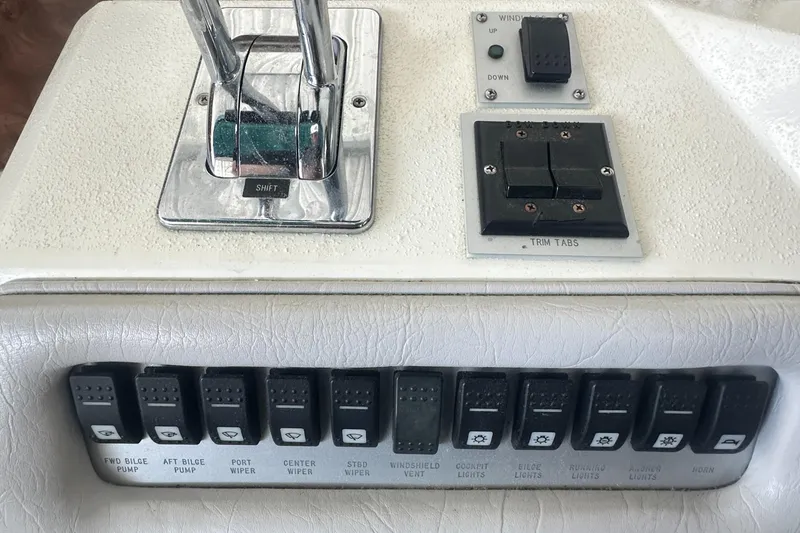 Slide: The Image of Control panel of a 1994 Sea Ray 370 Express Cruiser with switches and throttle levers. - 26