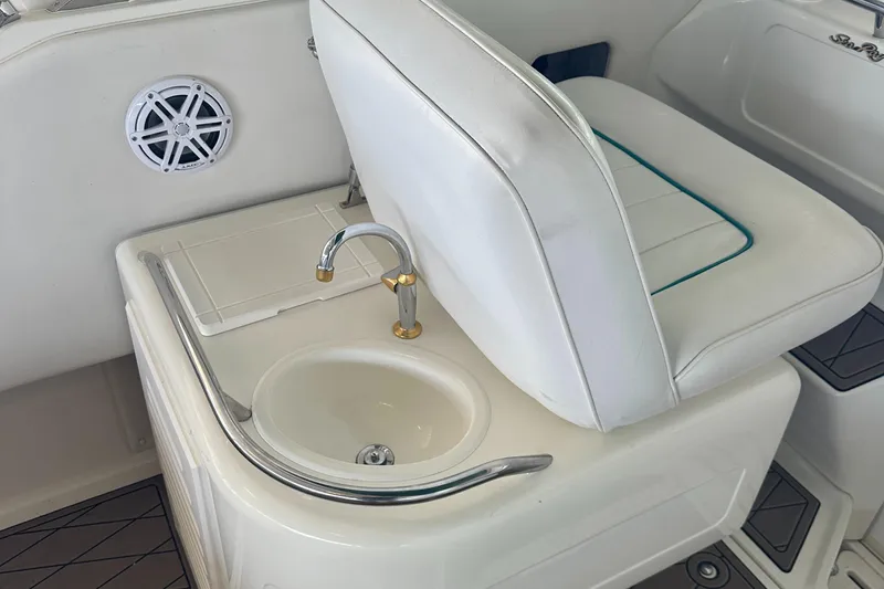 Slide: The Image of 1994 Sea Ray 370 Express Cruiser interior with white seating and built-in sink. - 27