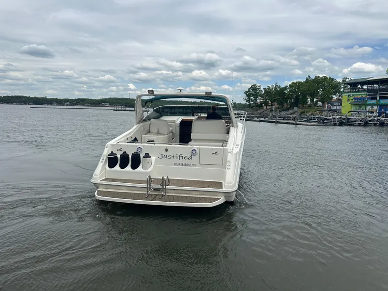 Slide: The Image of 1994 Sea Ray 370 Express Cruiser on calm water, rear view with open deck. - 3