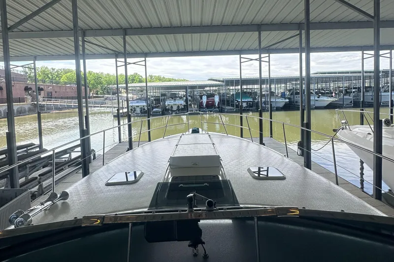 Slide: The Image of 1994 Sea Ray 370 Express Cruiser docked in a covered marina, surrounded by water and boats. - 31