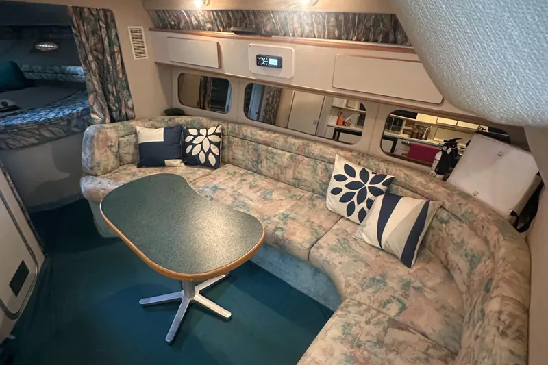 Slide: The Image of Interior of 1994 Sea Ray 370 Express Cruiser with cozy seating and decorative pillows. - 33