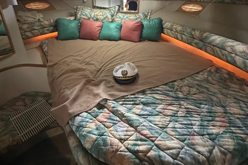 Slide: The Image of 1994 Sea Ray 370 Express Cruiser cabin with cozy bed and decorative pillows. - 45