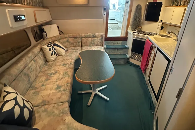Slide: The Image of 1994 Sea Ray 370 Express Cruiser interior with cozy seating and compact kitchen area. - 47