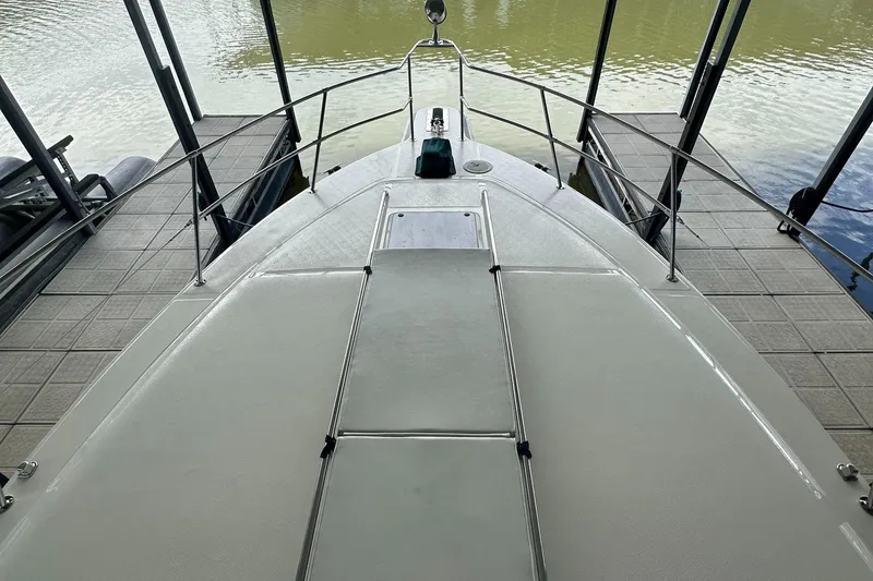 Slide: The Image of 1994 Sea Ray 370 Express Cruiser bow view at dock, showcasing sleek design and railing. - 49