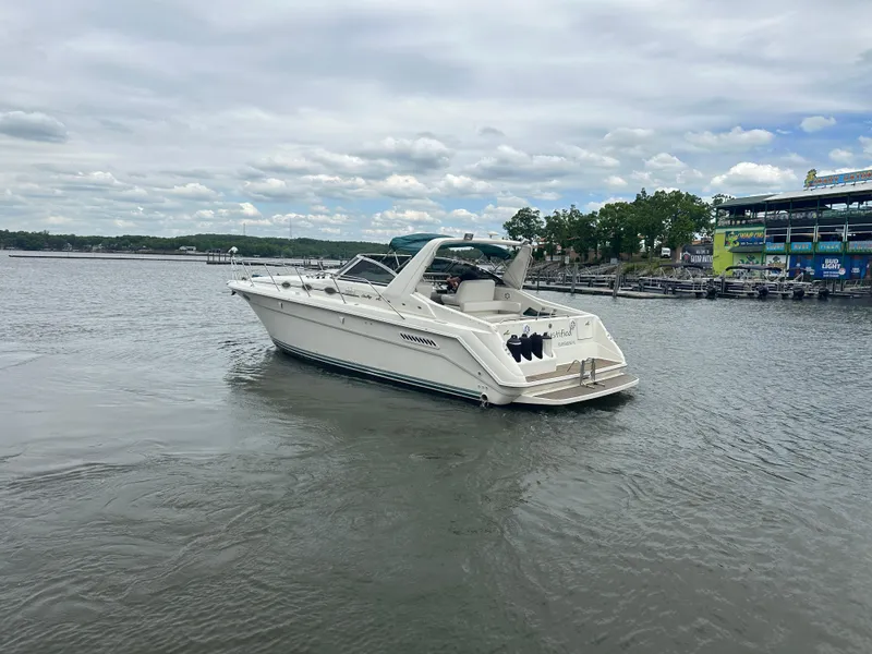 Slide: The Image of 1994 Sea Ray 370 Express Cruiser on a calm lake under a cloudy sky. - 5