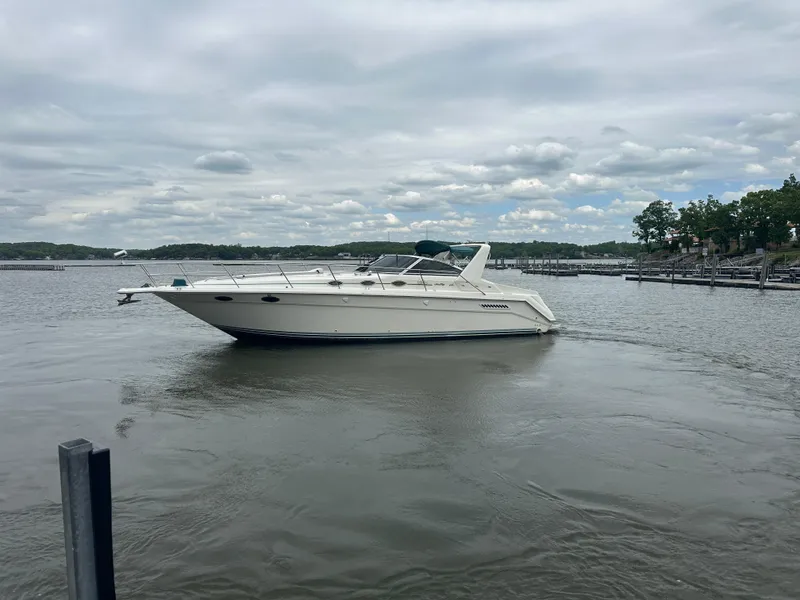 Slide: The Image of 1994 Sea Ray 370 Express Cruiser on calm water under cloudy sky. - 8