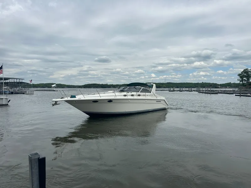 Slide: The Image of 1994 Sea Ray 370 Express Cruiser on a calm lake under a cloudy sky. - 9