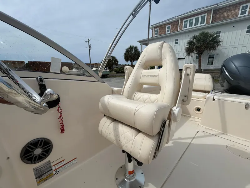 Slide: The Image of 2022 Grady-White Freedom 215 boat interior with plush captain's chair and steering wheel. - 11