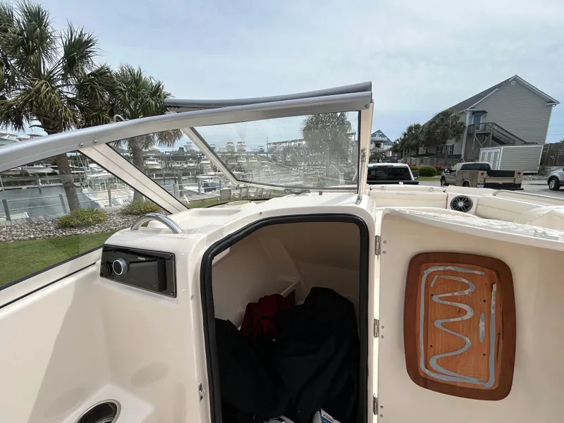 Slide: The Image of 2022 Grady-White Freedom 215 boat interior with open cabin door, marina view. - 16