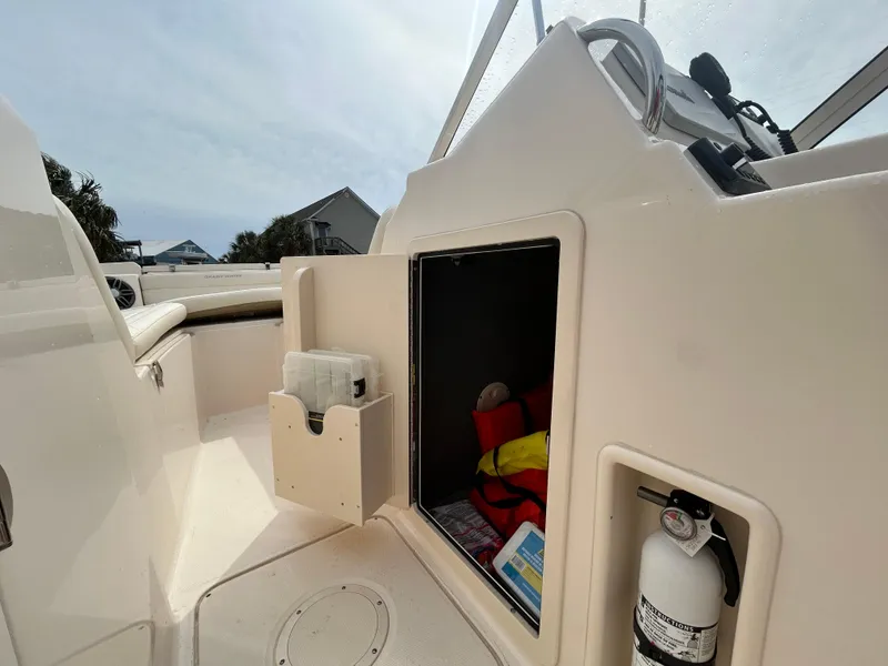 Slide: The Image of 2022 Grady-White Freedom 215 boat interior with storage compartment and safety equipment. - 17