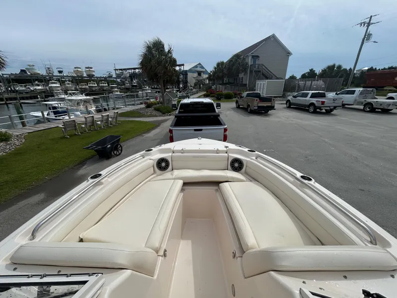 Slide: The Image of 2022 Grady-White Freedom 215 boat with spacious seating, parked near a marina. - 19