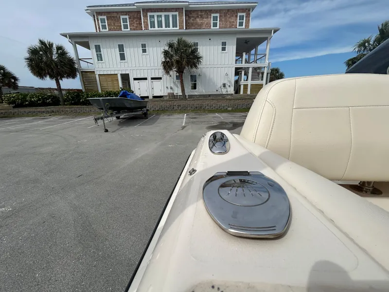 Slide: The Image of 2022 Grady-White Freedom 215 boat parked near a coastal house. - 24