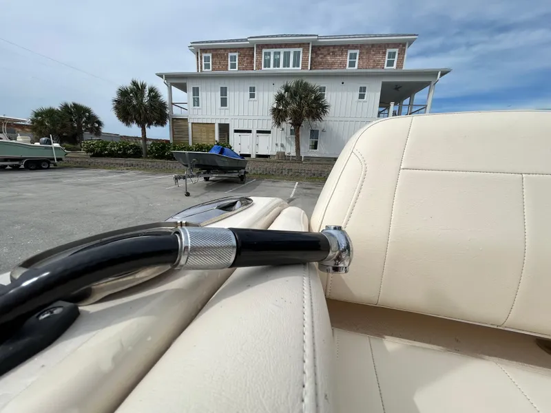 Slide: The Image of 2022 Grady-White Freedom 215 boat interior with a coastal house in the background. - 25