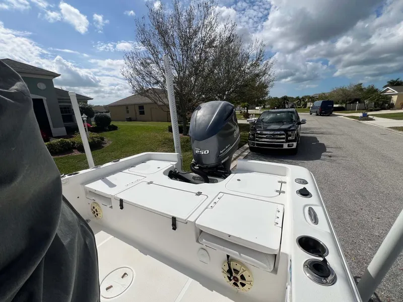 Slide: The Image of 2014 Sea Hunt SXS boat with outboard motor parked on a residential street. - 11