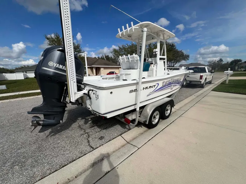 Slide: The Image of 2014 Sea Hunt SXS boat on trailer with Yamaha engine, parked on suburban street. - 14
