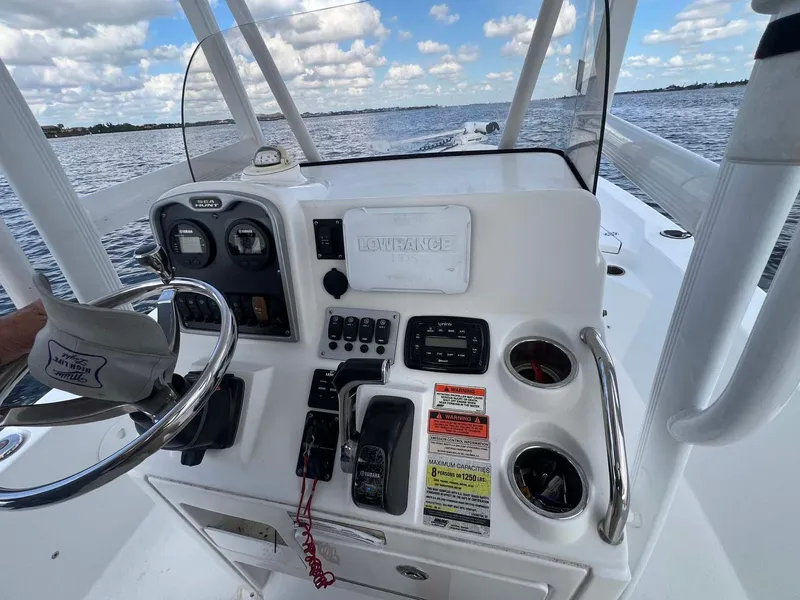 Slide: The Image of 2014 Sea Hunt SXS boat dashboard with steering wheel and controls on open water. - 7
