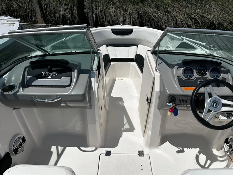 Slide: The Image of 2017 Chaparral 21 H2O Sport OB boat interior with steering wheel and seating. - 10