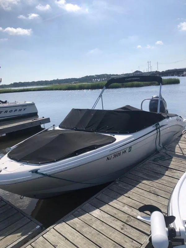 Slide: The Image of 2017 Chaparral 21 H2O Sport OB boat docked by a serene lake. - 2