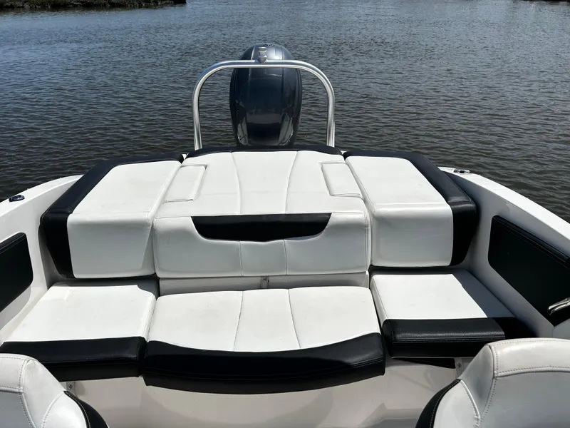 Slide: The Image of 2017 Chaparral 21 H2O Sport OB boat with white and black seating on calm water. - 8