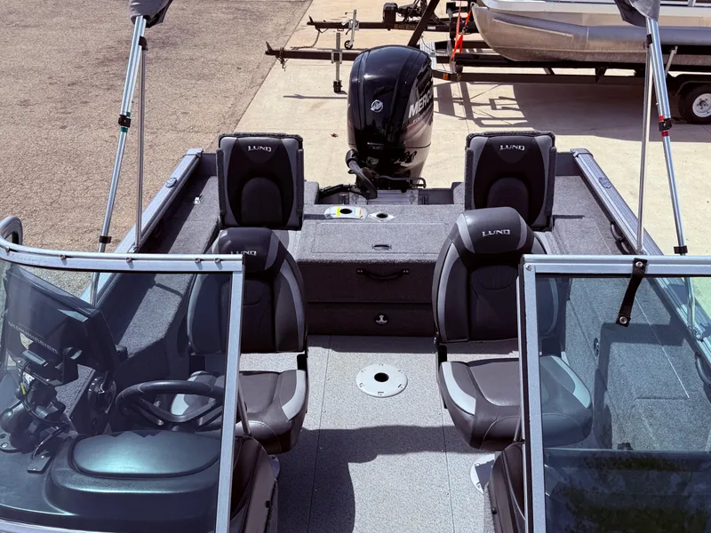 Slide: The Image of 2018 Lund 1675 Impact Sport boat interior with seating and Mercury outboard motor. - 16