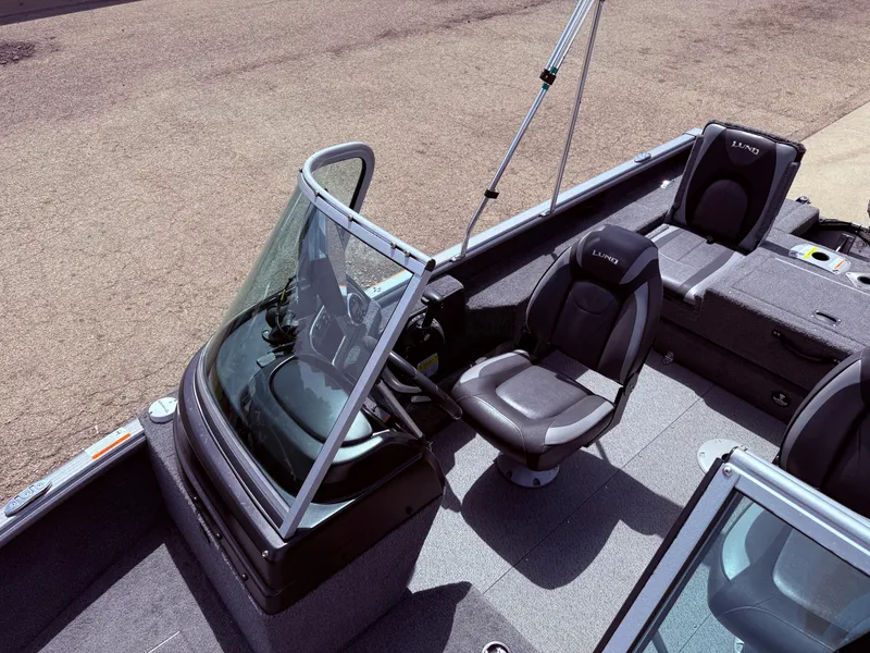 Slide: The Image of 2018 Lund 1675 Impact Sport boat interior with steering console and seating. - 17