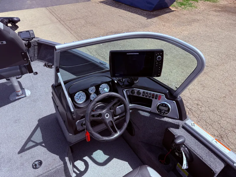Slide: The Image of 2018 Lund 1675 Impact Sport boat dashboard with steering wheel and navigation system. - 18