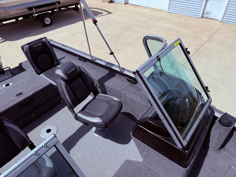Slide: The Image of 2018 Lund 1675 Impact Sport boat interior with seating and windshield. - 20