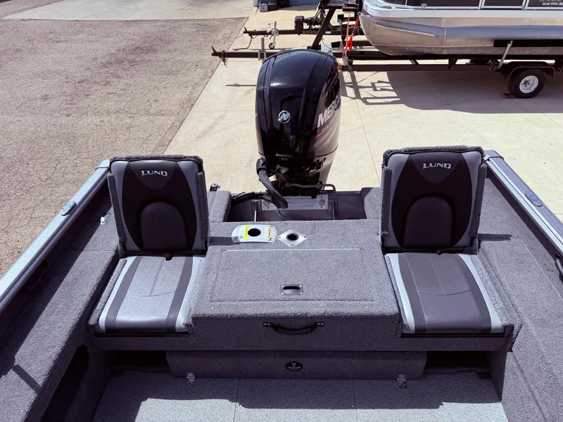 Slide: The Image of 2018 Lund 1675 Impact Sport boat interior with two seats and Mercury outboard motor. - 26