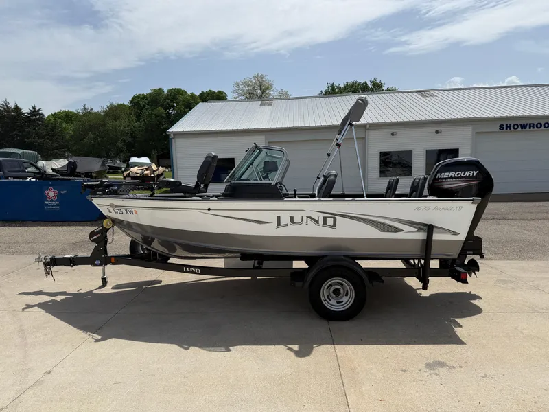 Slide: The Image of 2018 Lund 1675 Impact Sport boat on trailer, parked outside a showroom. - 3