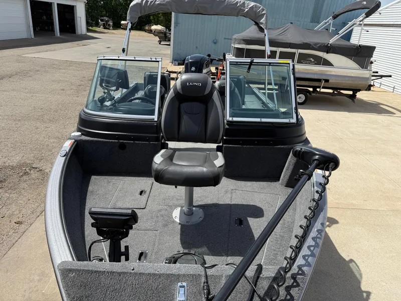 Slide: The Image of 2018 Lund 1675 Impact Sport boat with seating and windshield, parked outdoors. - 7
