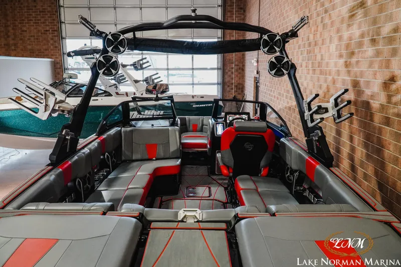 Slide: The Image of 2021 Malibu 23 LSV boat interior with red and gray seating at Lake Norman Marina. - 10