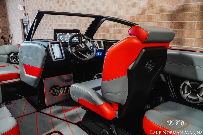 Slide: The Image of 2021 Malibu 23 LSV boat interior with red and gray seating, modern dashboard. - 14