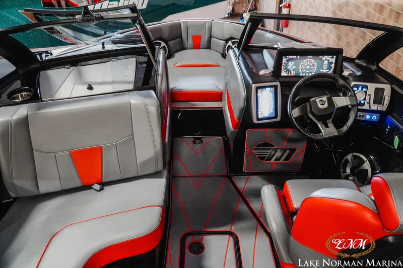 Slide: The Image of 2021 Malibu 23 LSV boat interior with modern dashboard and red-gray seating. - 15