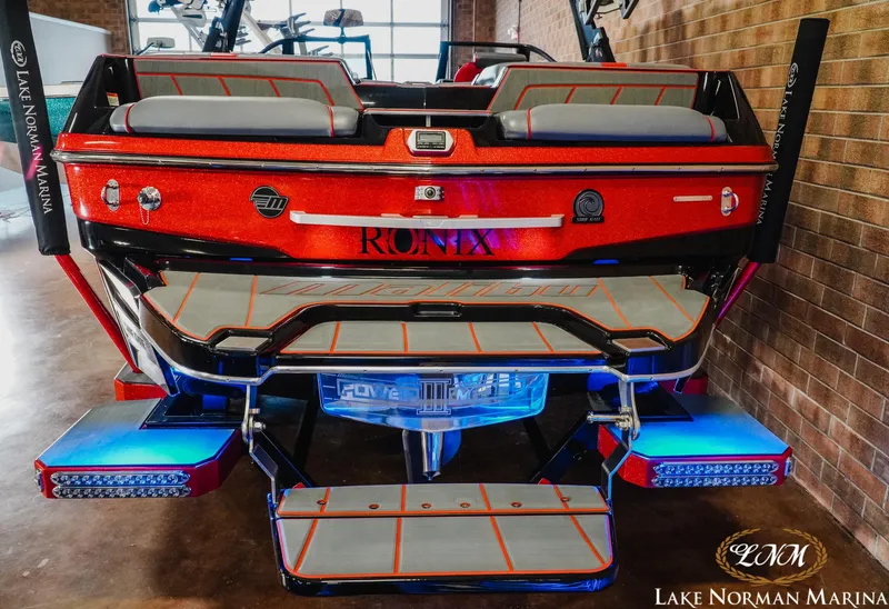 Slide: The Image of 2021 Malibu 23 LSV boat with vibrant red finish and illuminated platform at Lake Norman Marina. - 8