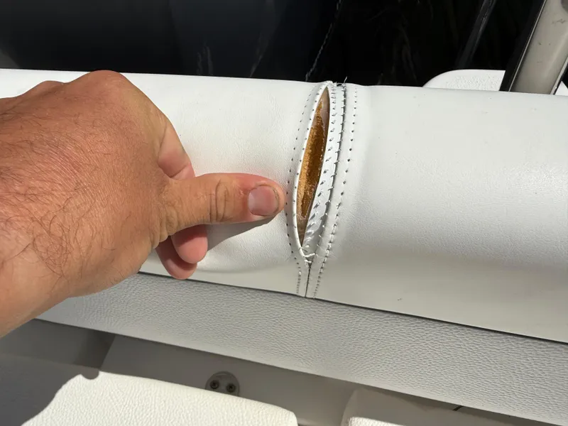 Slide: The Image of Torn upholstery on 2014 Sea Hunt Ultra 211 boat seat, showing interior padding. - 17