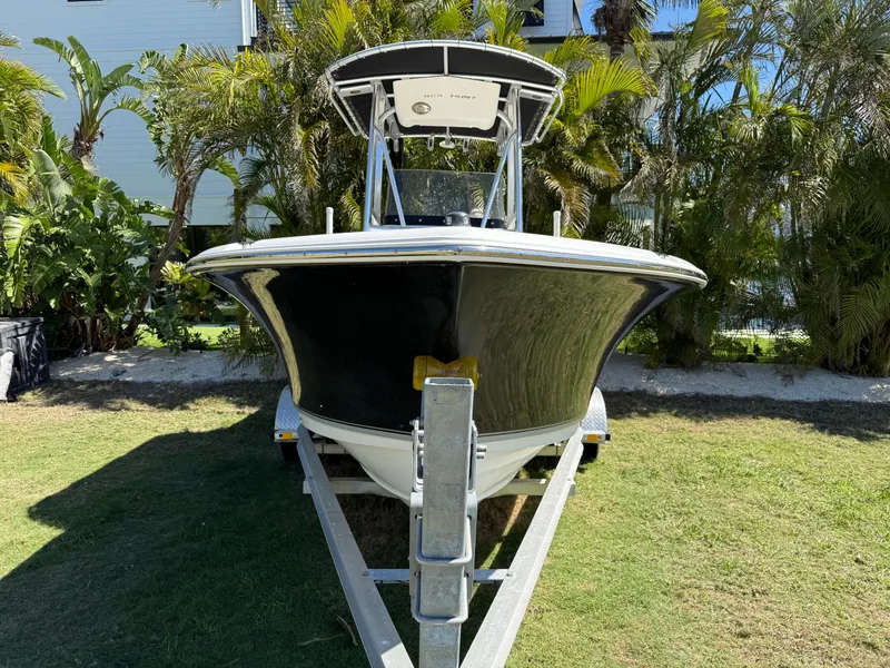 Slide: The Image of 2014 Sea Hunt Ultra 211 boat on trailer, surrounded by lush greenery. - 2