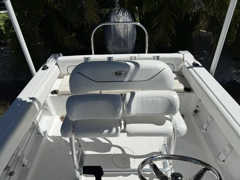 Slide: The Image of 2014 Sea Hunt Ultra 211 boat interior with white seating and steering wheel. - 24