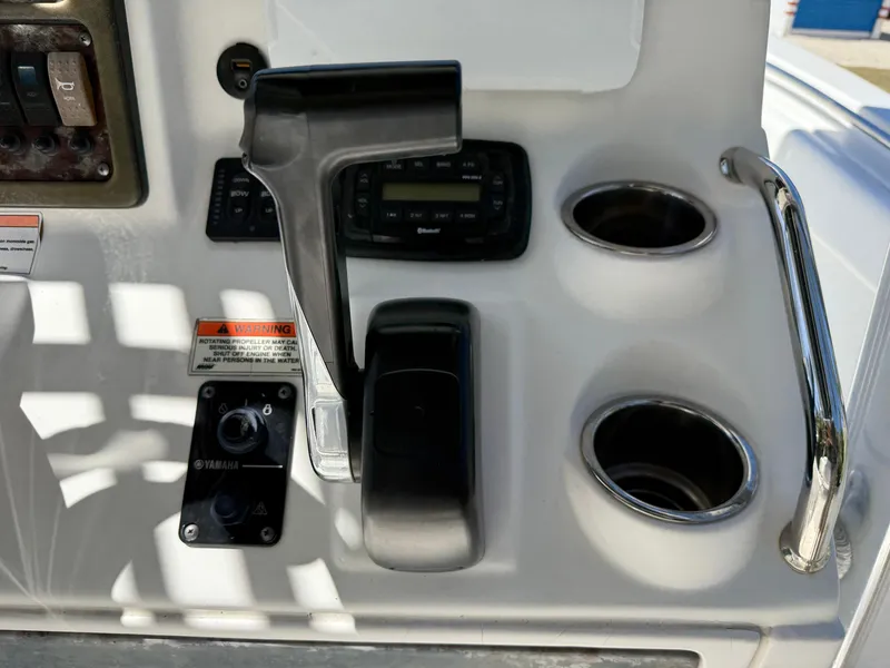 Slide: The Image of Control panel of 2014 Sea Hunt Ultra 211 boat with throttle and cup holders. - 34