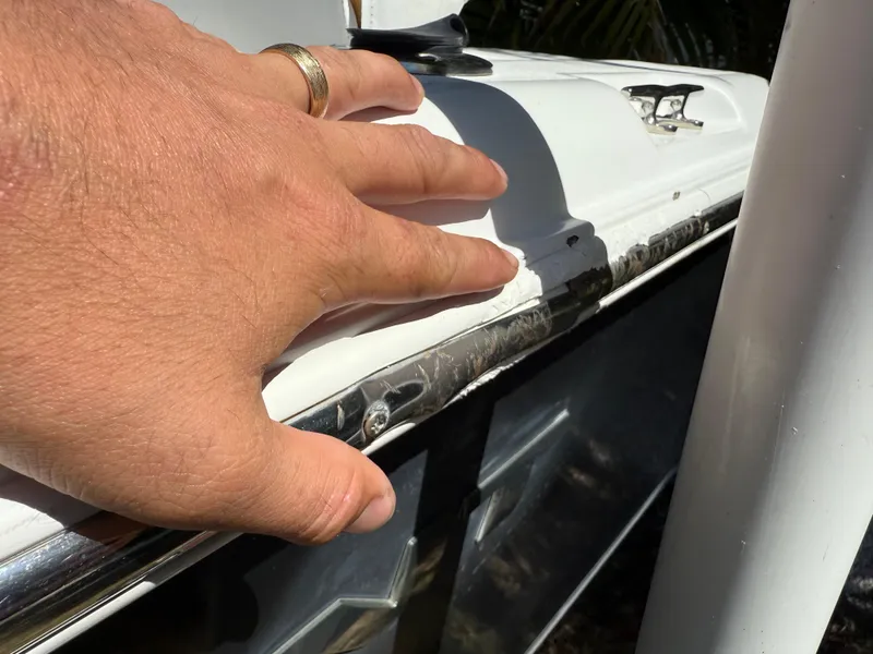 Slide: The Image of Hand inspecting 2014 Sea Hunt Ultra 211 boat's exterior detailing. - 6