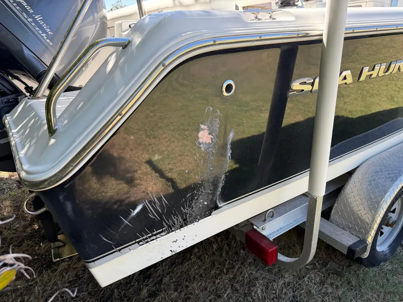 Slide: The Image of 2014 Sea Hunt Ultra 211 boat with visible hull scratches on a trailer. - 8