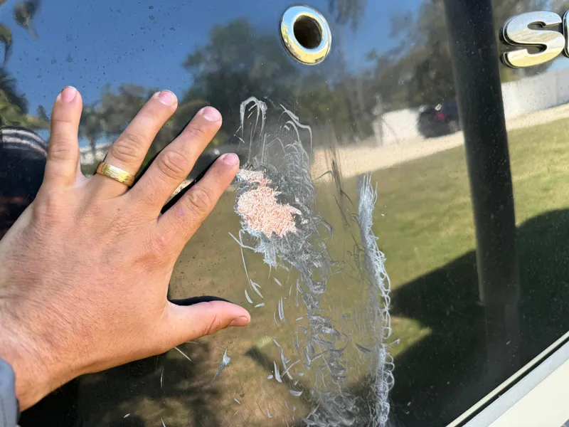 Slide: The Image of Hand inspecting damage on 2014 Sea Hunt Ultra 211 boat hull. - 9