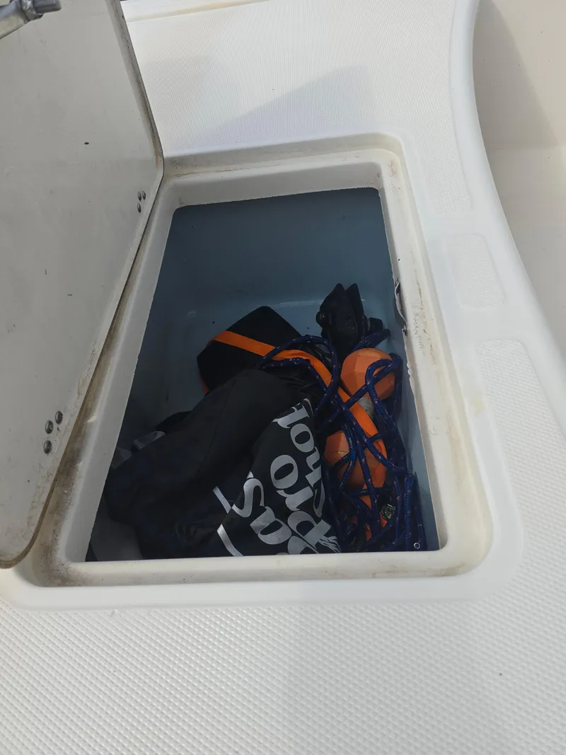 Slide: The Image of Storage compartment on a 2019 Mako Pro Skiff 17 CC boat with gear inside. - 5