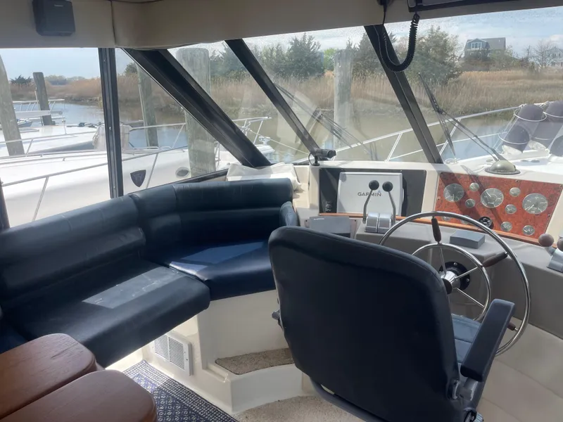 Slide: The Image of 1999 Bayliner 4788 Motoryacht helm with seating, steering wheel, and control panel. - 11