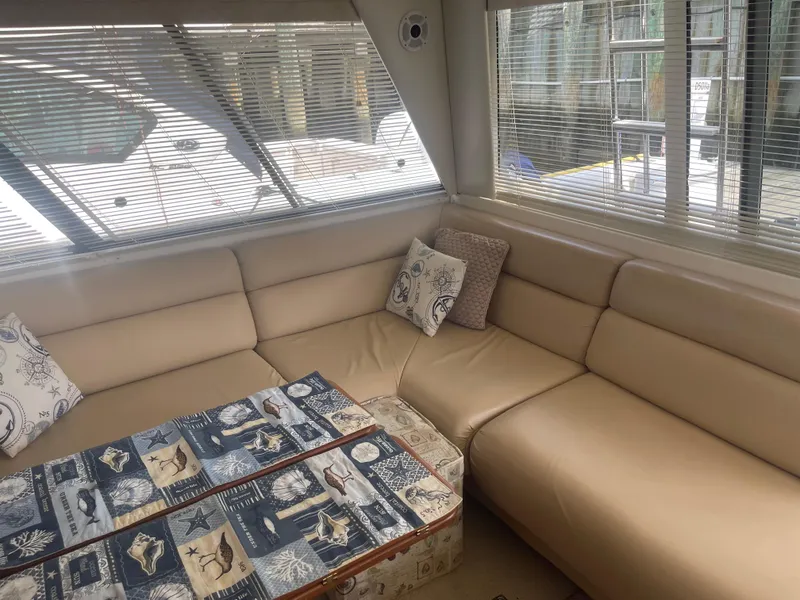 Slide: The Image of 1999 Bayliner 4788 Motoryacht interior with beige leather seating and nautical-themed decor. - 17