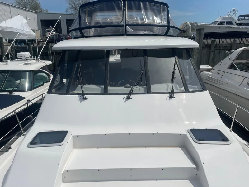 Slide: The Image of 1999 Bayliner 4788 Motoryacht, front view, docked among other boats. - 5